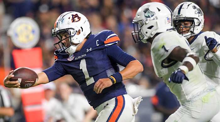 Pyton Thorne reaches with the football in one hand as two Samford players chase him